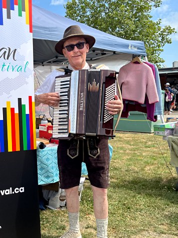 Gary Wenzlaff playing beside the European Festival banner on a sunny afternoon.