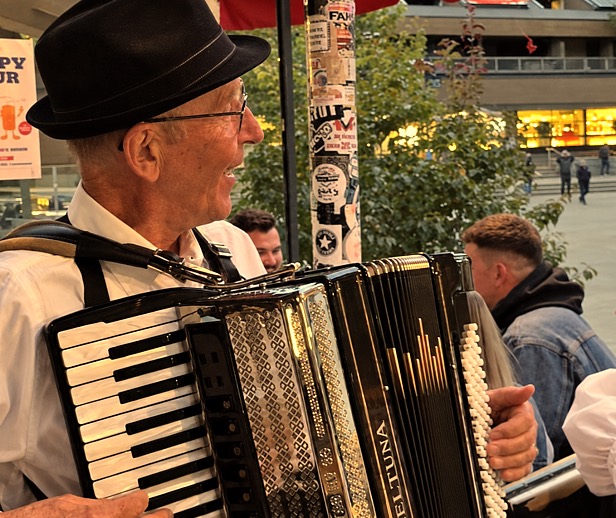 Gary Wenzlaff playing his accordion at an outdoor evening performance.